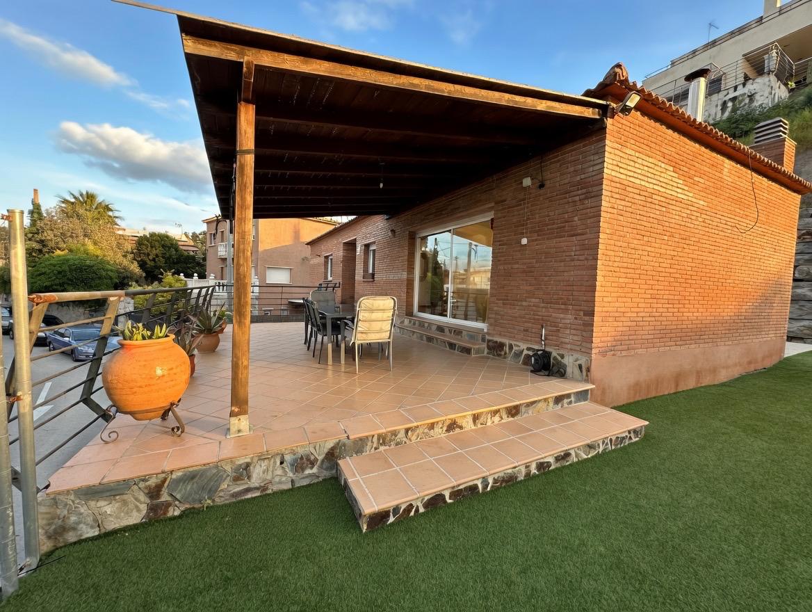 Porche exterior junto a la fachada de obra vista